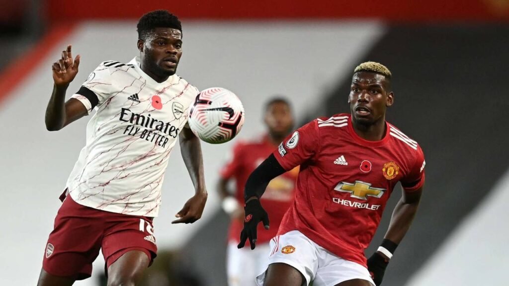 Thomas Partey challenging Paul Pogba during Premier League match.