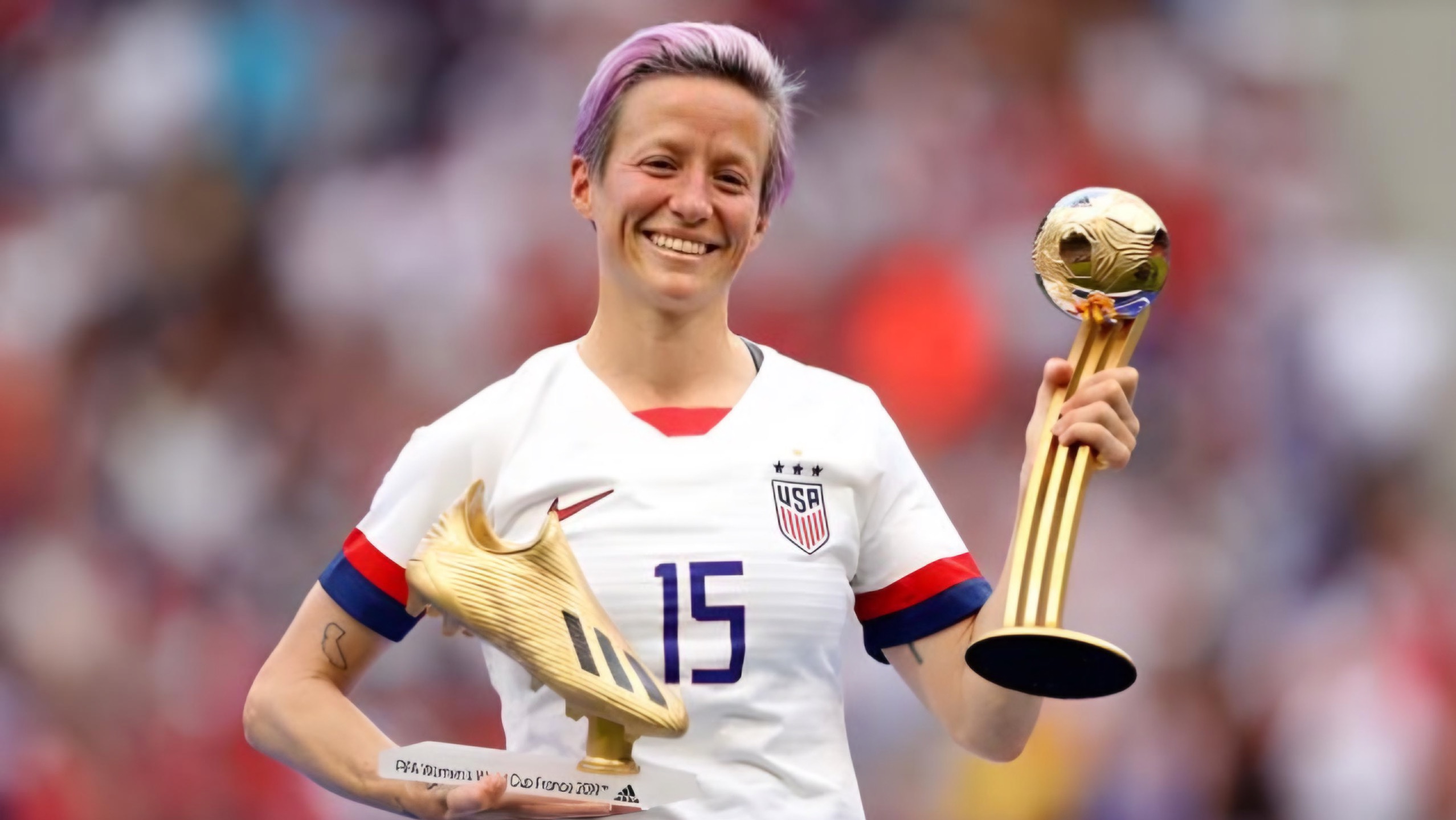 Megan Rapinoe smiling with his two awards