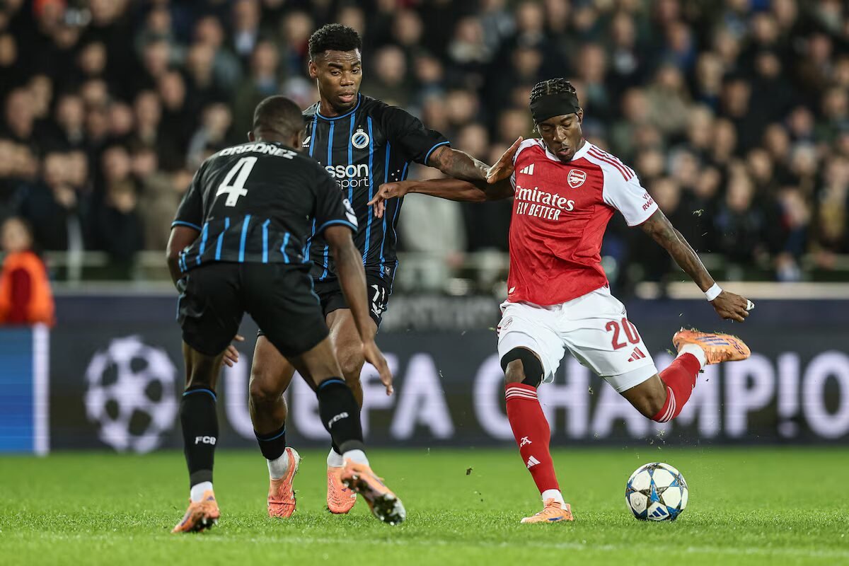 raphael onyedika battles with noni madueke during a ucl match between arsenal and club brugge