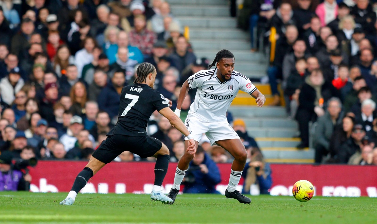 fulham midfielder alex iwobi battles for the ball against tottenham hotspur’s xavi simons